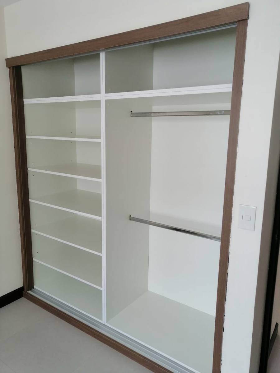 Closet de puertas corredizas blanco con marco en nogal